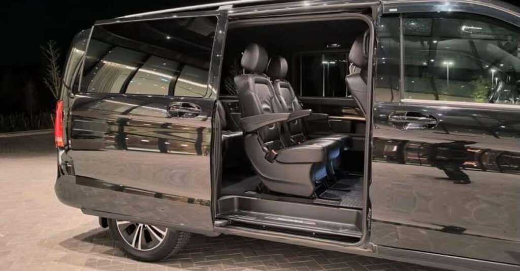 Interior of a 6-seater minivan in Tbilisi with open passenger door during an evening transfer